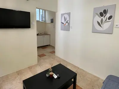 a living room with a table and a flat screen tv at Heart of Athens thiseio (2) in Athens