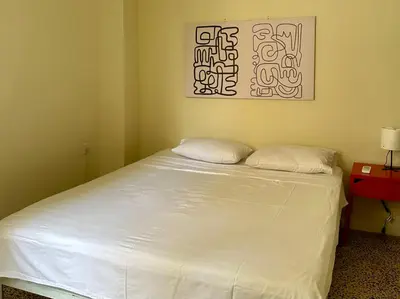 a white bed in a room with a picture on the wall at Heart of Athens thiseio (2) in Athens