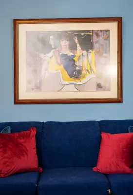 a painting above a blue couch with two red pillows at Bravo 2 City Center Room in Athens