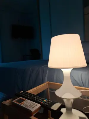 a lamp sitting on a table with a remote control at Νέο στούντιο, Νέος Κόσμος in Athens