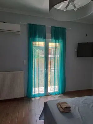 a bedroom with a bed and a window with blue curtains at Νέο στούντιο, Νέος Κόσμος in Athens