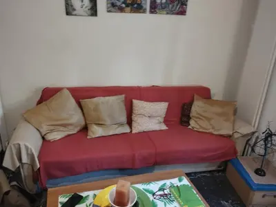 a red couch in a living room with pillows at Central appartement in Athens