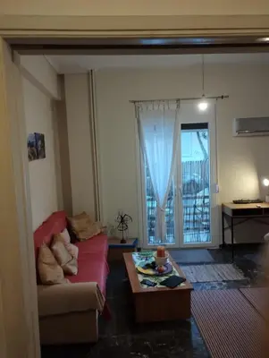 a living room with a red couch and a table at Central appartement in Athens