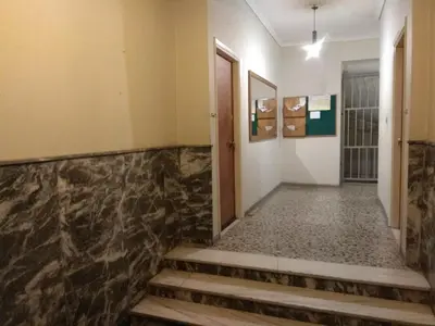 a hallway of a building with stairs and paintings on the wall at Central appartement in Athens
