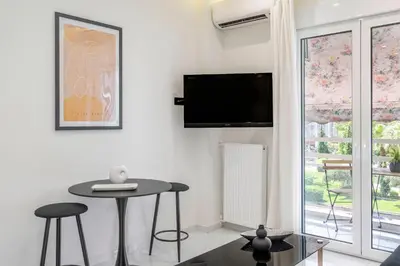 a living room with a table and a tv on the wall at Central 2BR Apartment in the Heart of Athens in Athens