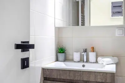 a white bathroom with a sink and a mirror at Central 2BR Apartment in the Heart of Athens in Athens