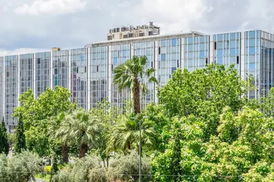 a tall glass building with trees in front of it at Central 2BR Apartment in the Heart of Athens in Athens