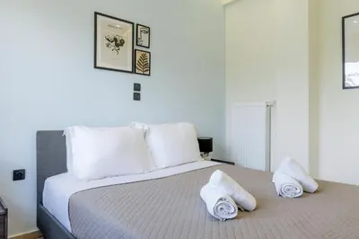 a white bedroom with a bed with towels on it at Central 2BR Apartment in the Heart of Athens in Athens
