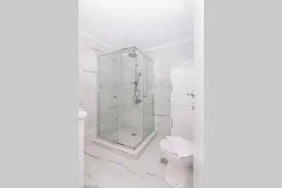 a white bathroom with a shower and a toilet at Sunlit 2BR Oasis in Metaxourghio 3min from metro in Athens