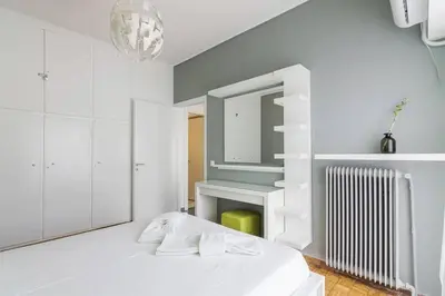 a white room with a bed and a mirror at Sunlit 2BR Oasis in Metaxourghio 3min from metro in Athens