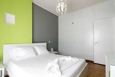 a bedroom with a white bed and a chandelier at Sunlit 2BR Oasis in Metaxourghio 3min from metro in Athens
