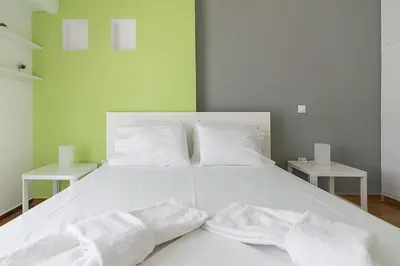 a white bed with two white towels on it at Sunlit 2BR Oasis in Metaxourghio 3min from metro in Athens