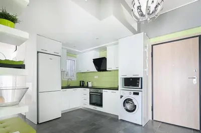 a kitchen with white cabinets and a washer and dryer at Sunlit 2BR Oasis in Metaxourghio 3min from metro in Athens