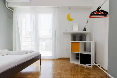 a white bedroom with a bed and a window at Sunlit 2BR Oasis in Metaxourghio 3min from metro in Athens