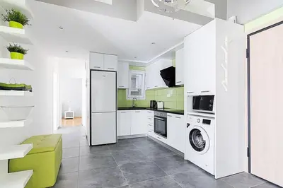 a kitchen with white appliances and green and white walls at Sunlit 2BR Oasis in Metaxourghio 3min from metro in Athens