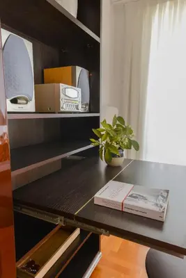 a table with a book on a shelf with a plant at Φωτεινό κομψό & άνετο διαμέρισμα κοντά στο κέντρο! in Athens