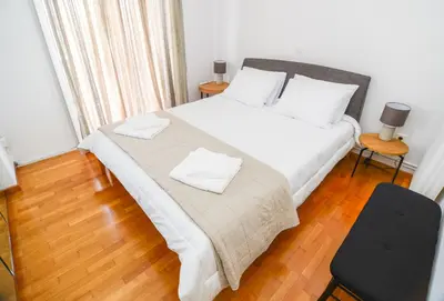 a bedroom with a bed with two white towels on it at Φωτεινό κομψό & άνετο διαμέρισμα κοντά στο κέντρο! in Athens