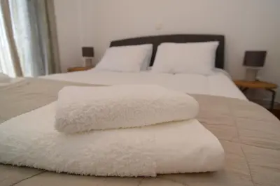 a pile of white towels sitting on top of a bed at Φωτεινό κομψό & άνετο διαμέρισμα κοντά στο κέντρο! in Athens