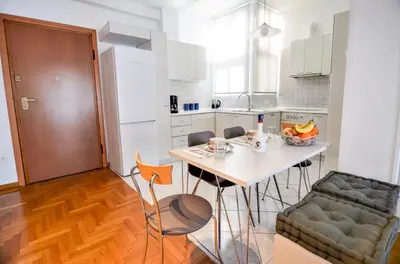 a kitchen with a table and chairs in a room at Φωτεινό κομψό & άνετο διαμέρισμα κοντά στο κέντρο! in Athens
