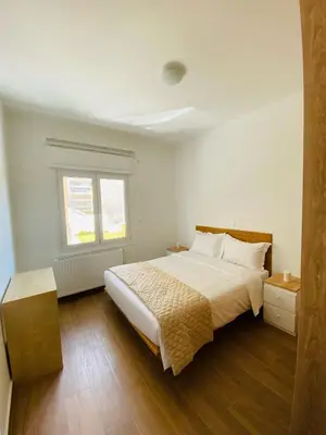 a white bedroom with a bed and a window at Le musée in Athens