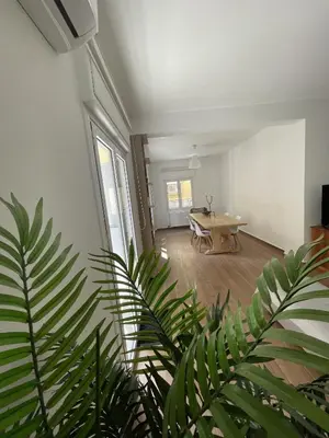 a living room with a table and a large plant at Le musée in Athens