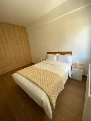 a bedroom with a large white bed and wooden floors at Le musée in Athens