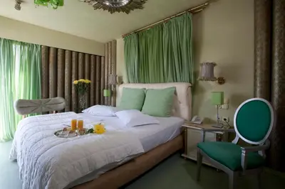 a bedroom with a bed with a table and a chair at The Crystal Blue Hotel in Athens