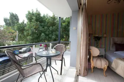 a balcony with a table and chairs and a bed at The Crystal Blue Hotel in Athens