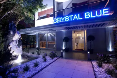 a hotel entrance with a blue sign and a fountain at The Crystal Blue Hotel in Athens