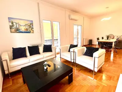 a living room with two white couches and a table at Hellenic Pleasure Residences in Athens