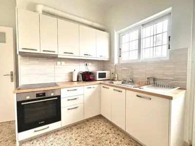 a white kitchen with white cabinets and a microwave at Hellenic Pleasure Residences in Athens