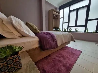 a bedroom with a bed with a purple blanket at Ellis Apartment in Athens