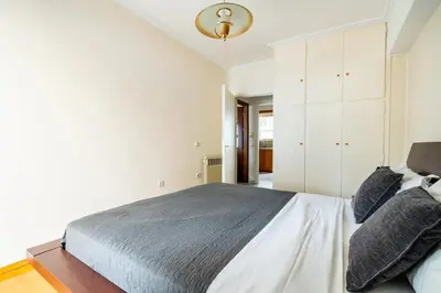 a bedroom with a bed and a white cabinet at Live like an Athenian! in Athens