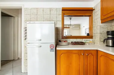 a kitchen with a white refrigerator and wooden cabinets at Live like an Athenian! in Athens