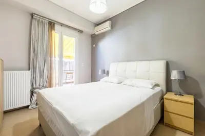 a white bedroom with a large bed and a window at Best Family House,Acropolis view,5 min from metro in Athens