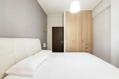 a bedroom with a white bed and a wooden door at Best Family House,Acropolis view,5 min from metro in Athens