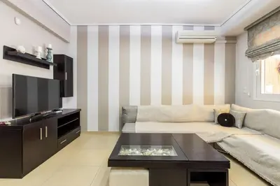 a living room with a couch and a tv at Best Family House,Acropolis view,5 min from metro in Athens