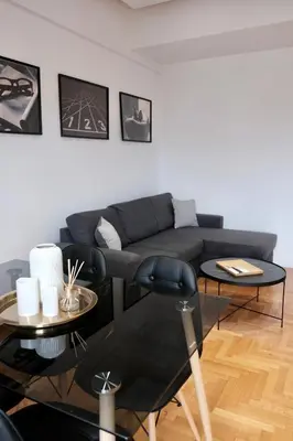 a living room with a couch and two tables at SynPiraeus Apartments & Studios in Piraeus