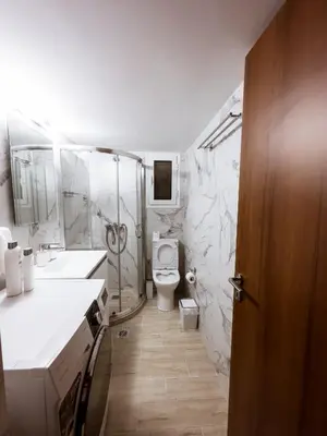 a white bathroom with a toilet and a sink at Metro Chic Haven: Modernized Urban Studio near the Tram in Athens