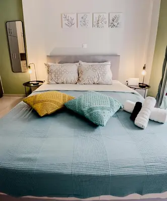 a bed with two pillows on top of it at Metro Chic Haven: Modernized Urban Studio near the Tram in Athens