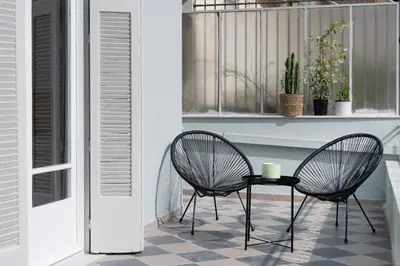 a patio with two chairs and a table on a tile floor at Jade in Athens