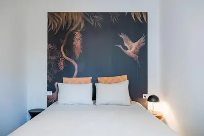 a bedroom with a large bed with a painting on the wall at Crane in Athens