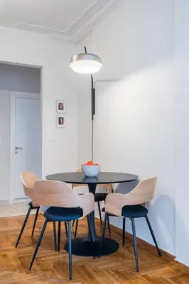 a dining room table with four chairs and a lamp at Crane in Athens