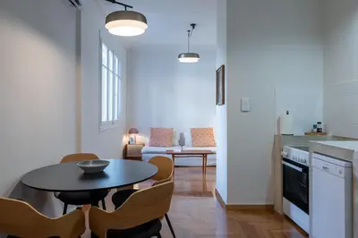 a kitchen and living room with a table and chairs at Crane in Athens