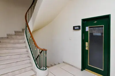 a staircase with a green door in a building at Athens central studio in front of Syntagma metro in Athens