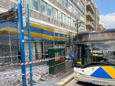 a bus is parked in front of a building at Athens central studio in front of Syntagma metro in Athens
