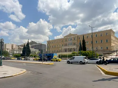 a busy city street with cars and a building at Athens central studio in front of Syntagma metro in Athens