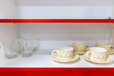 four cups and plates on a shelf with glasses at Bright Apartment In The Center VIPGreece in Athens