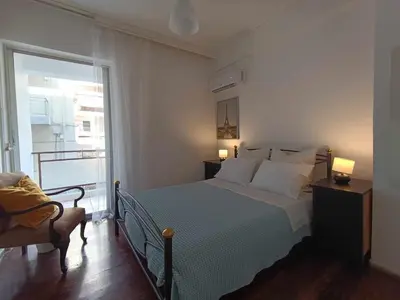a bedroom with a bed and a large window at Apartment by the Sepolia metro in Athens