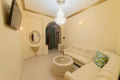 a living room with a white couch and a chandelier at Penthouse Oasis in Athens